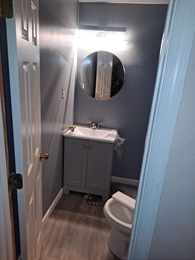 Half bath remodel with new vanity, mirror and vinyl plank flooring in Baltimore MD